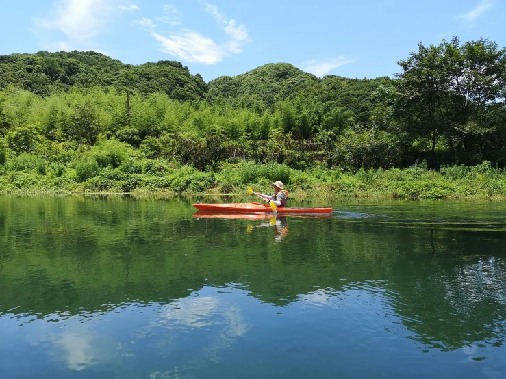 a man paddling in a red canoe