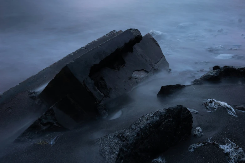 large rocks near ocean during the day with fog