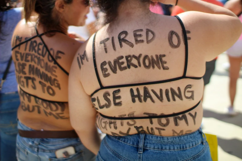 a woman that is wearing several words on her back