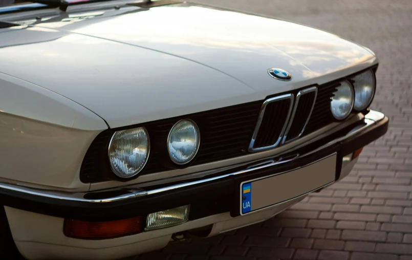 a classic bmw is parked on the side of a road