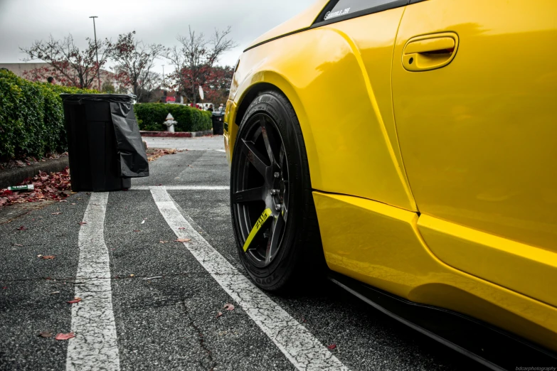 close up of the rear bumper and tire of an all - yellow sports car