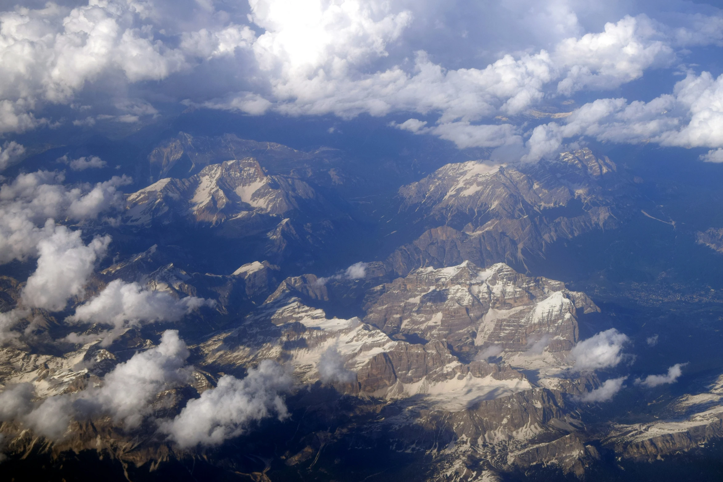 an aerial view of mountains and clouds and water