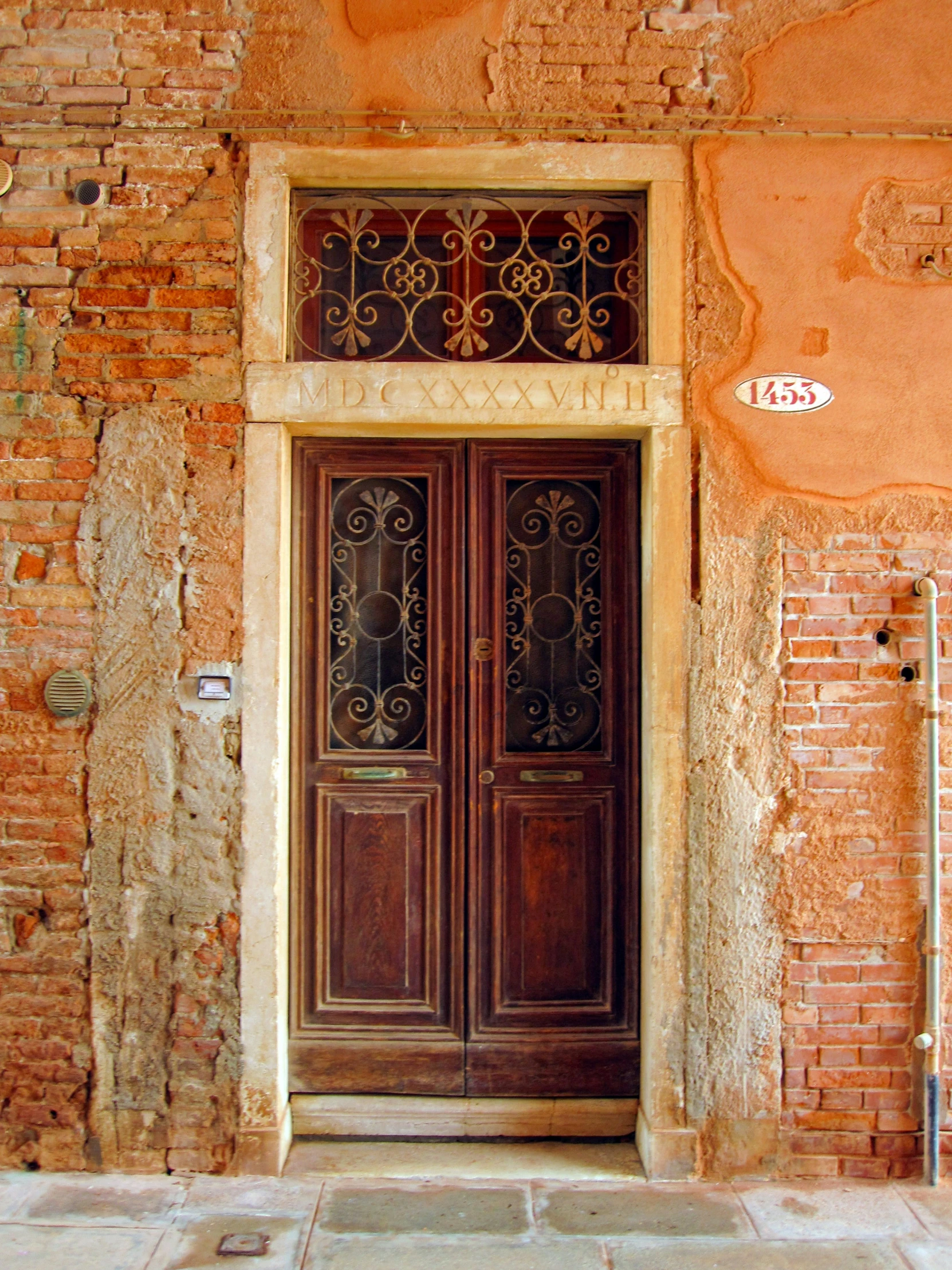 two brown doors with intricate designs on the top