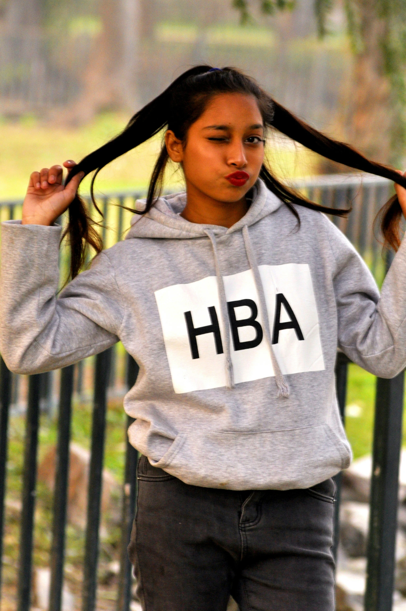 a girl with long hair standing in the park