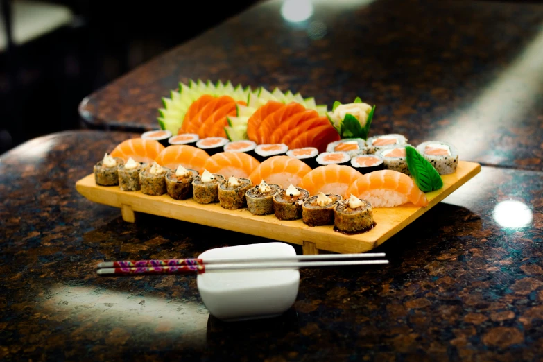 a wooden  board topped with sushi and chopsticks