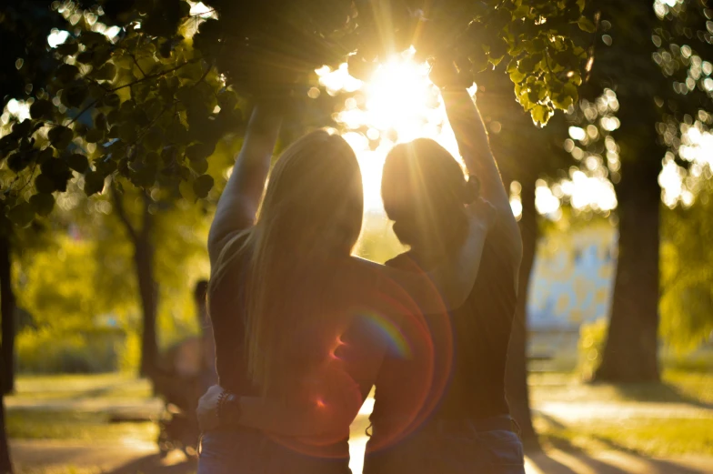 two young women enjoying the sunlight in the park