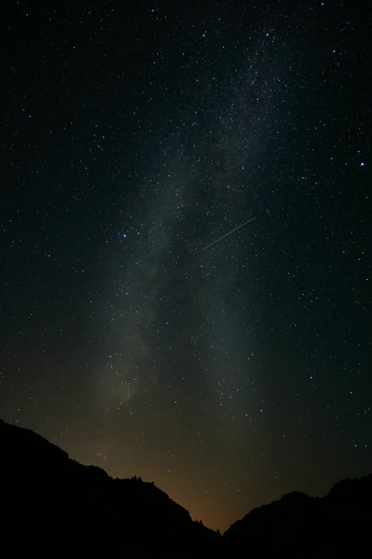 the night sky filled with stars and mountains