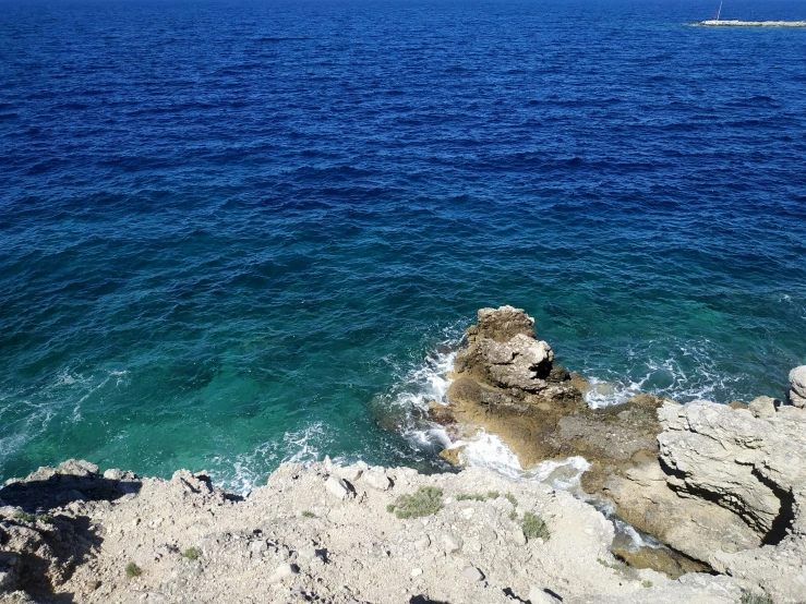 the ocean and rocky cliffs are seen from above