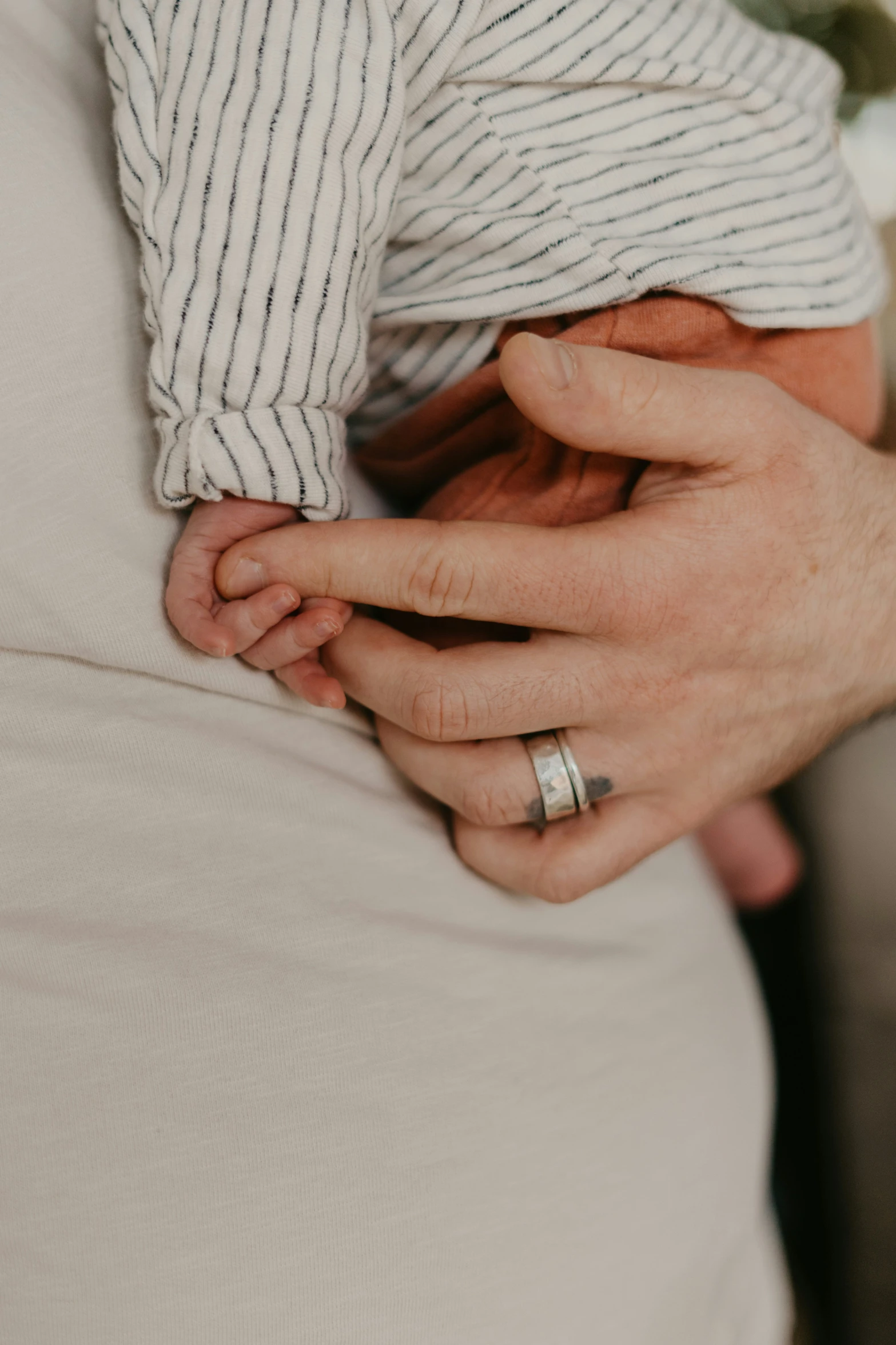 a close up view of a person holding his ring on her right arm