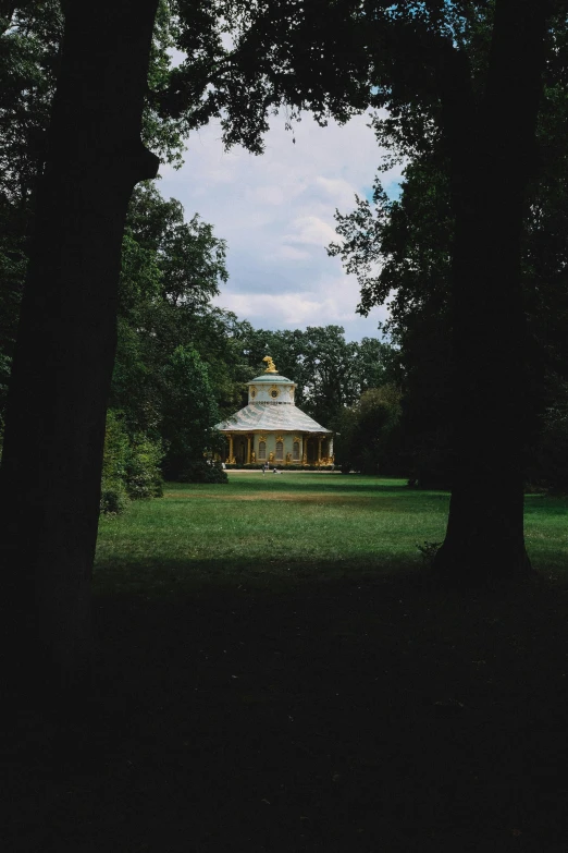 a gazebo in the distance between two trees