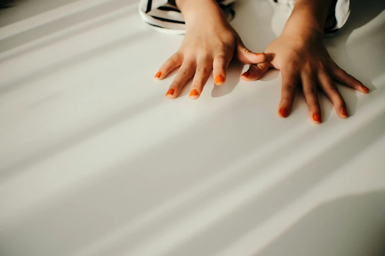 hands and toes that are sitting on a bed