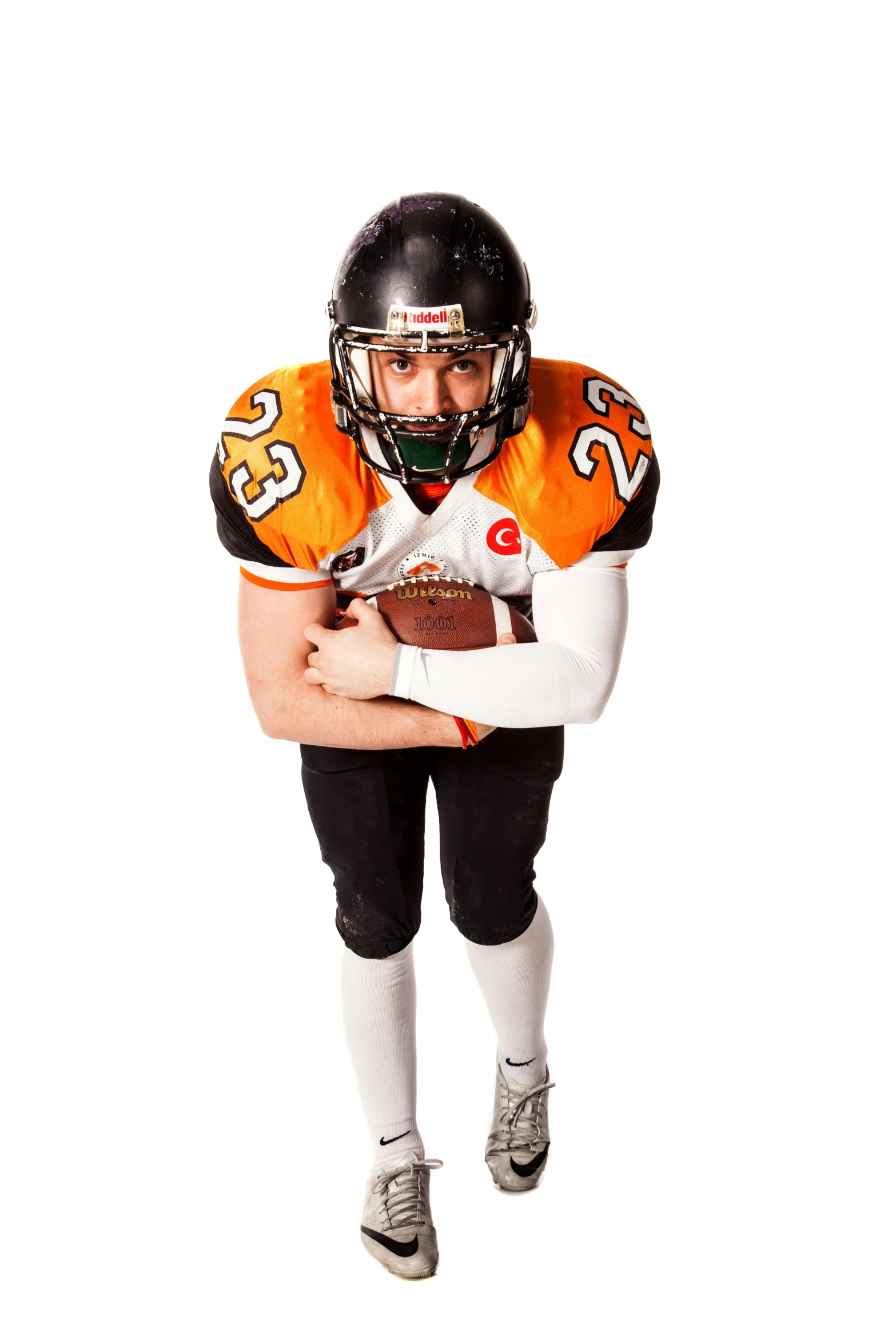 a football player holding onto a ball and posing for the camera