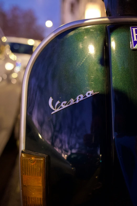 a vespa motorcycle that has the name of a business on it