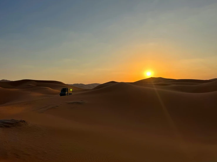 a truck traveling through the desert at sunset