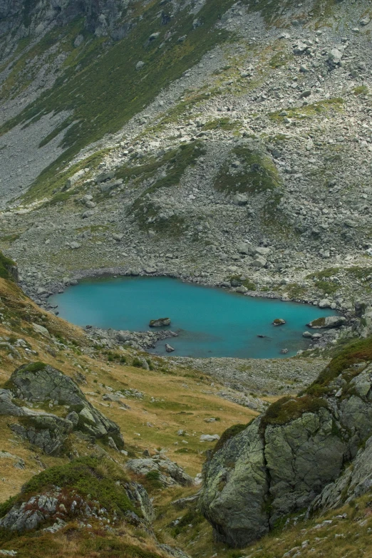 a small lake in the middle of a mountain