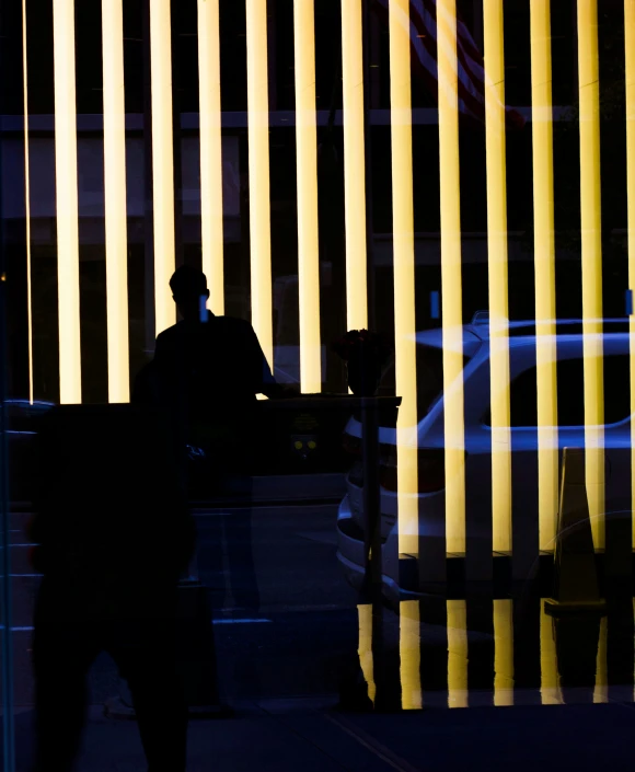 a man walking down the street next to a tall building