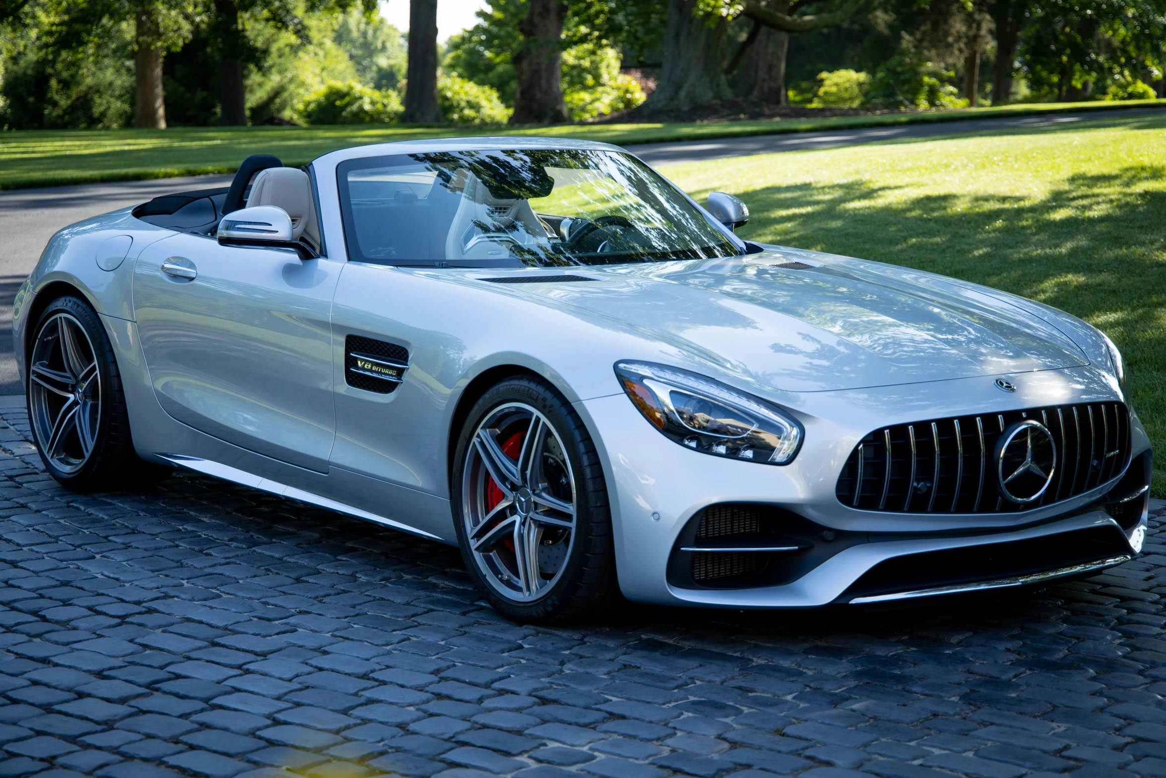 the mercedes amg gt roadster cab is parked on the sidewalk