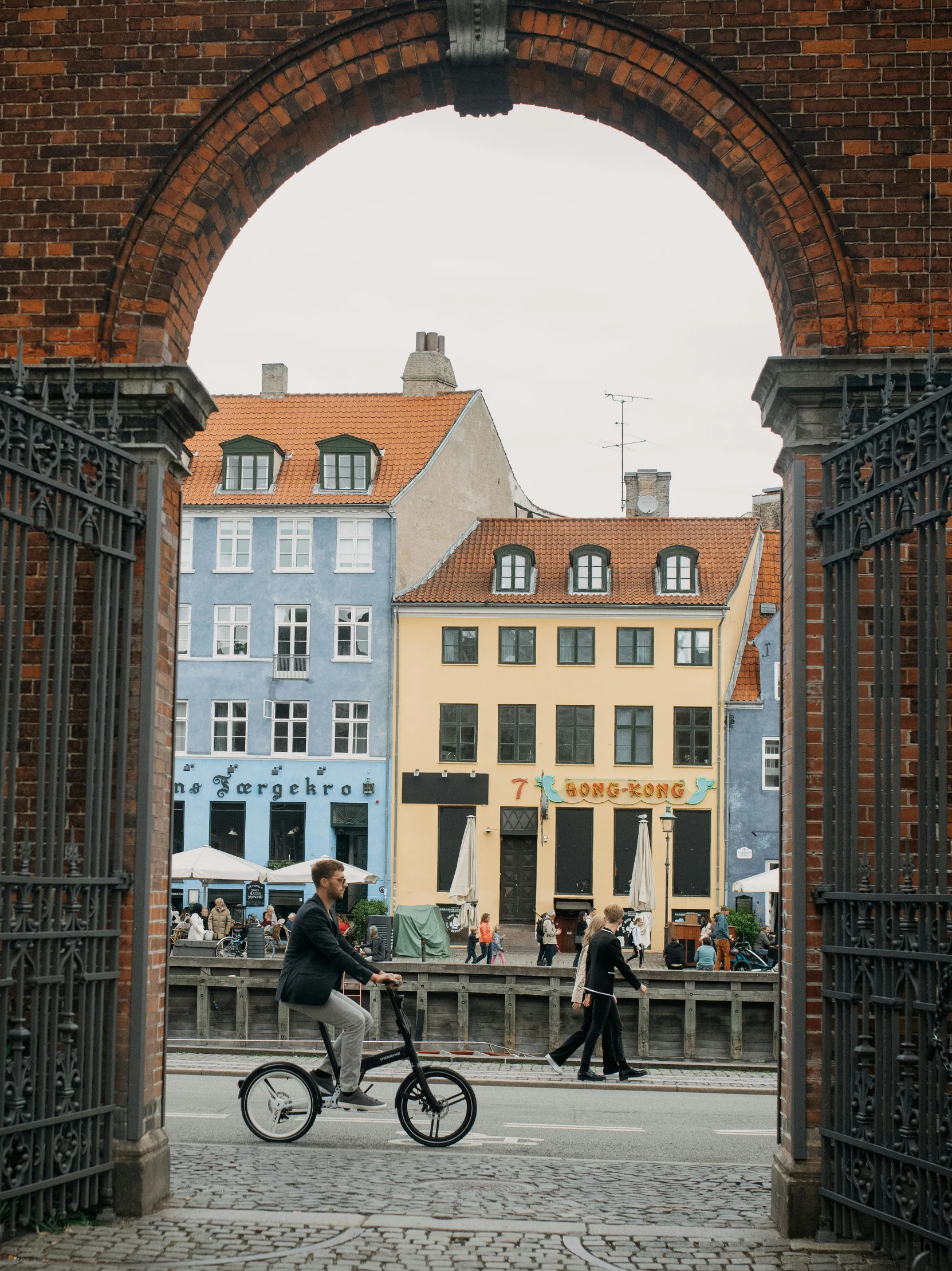 a pair of people riding bikes through an arch