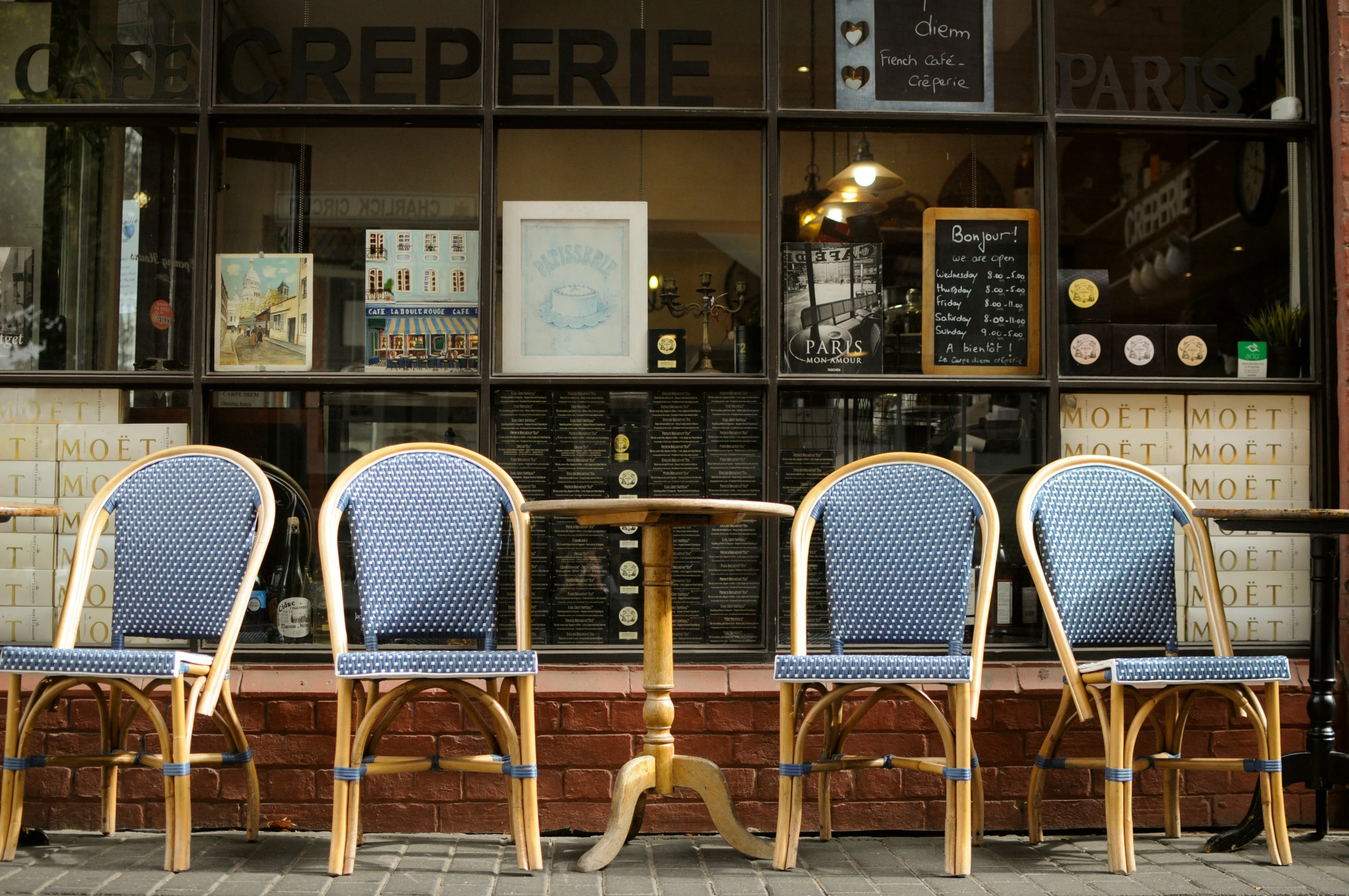 three chairs outside a restaurant waiting in front of a window