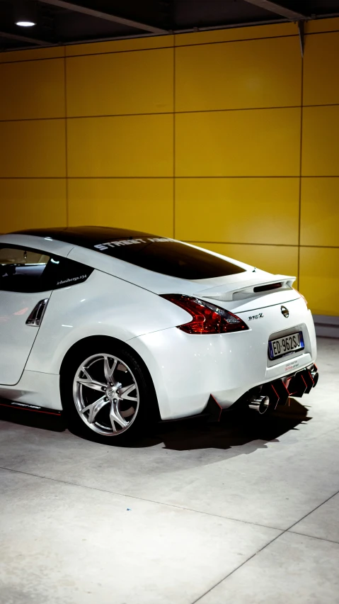 white car is parked on cement in a building