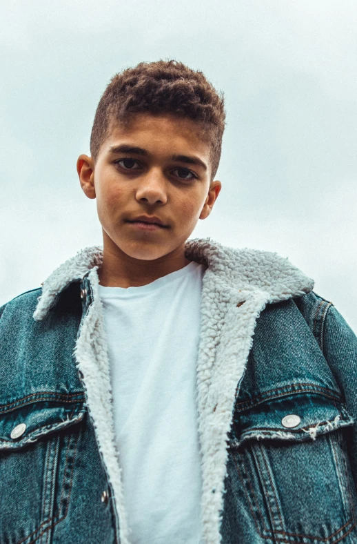 a young man wearing a denim jacket with sherpet on his coat