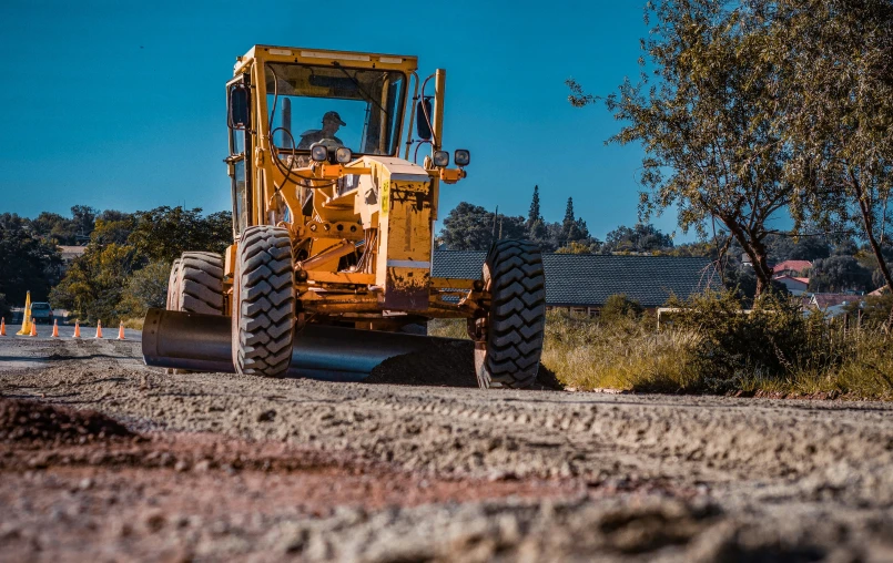 a bulldozer digging a dirt road while it is plowing