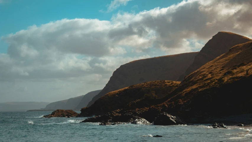 some clouds hang in the sky above some cliffs