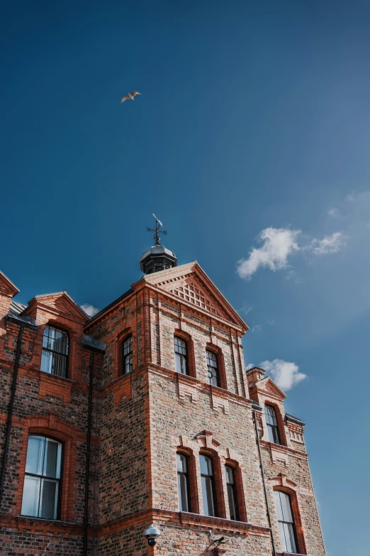 a bird is flying over a brick building