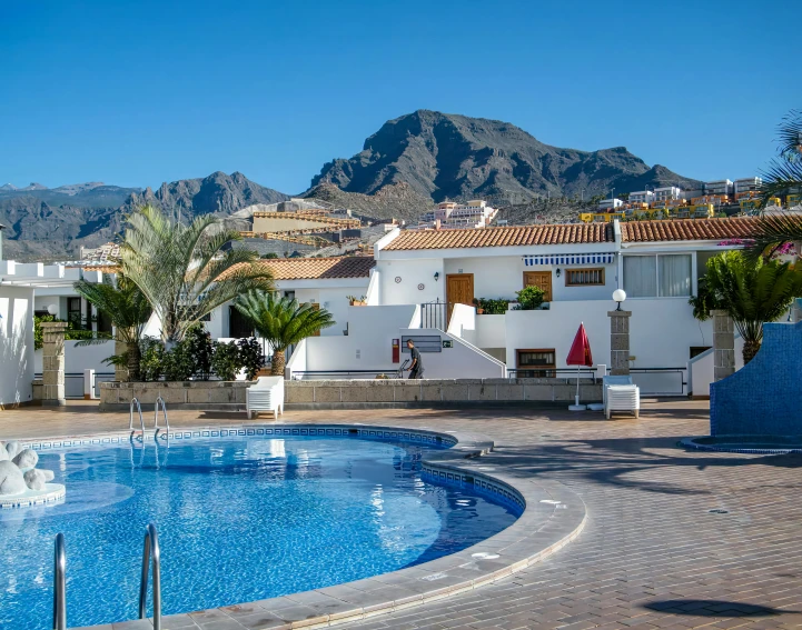 this is a swimming pool with mountains in the background