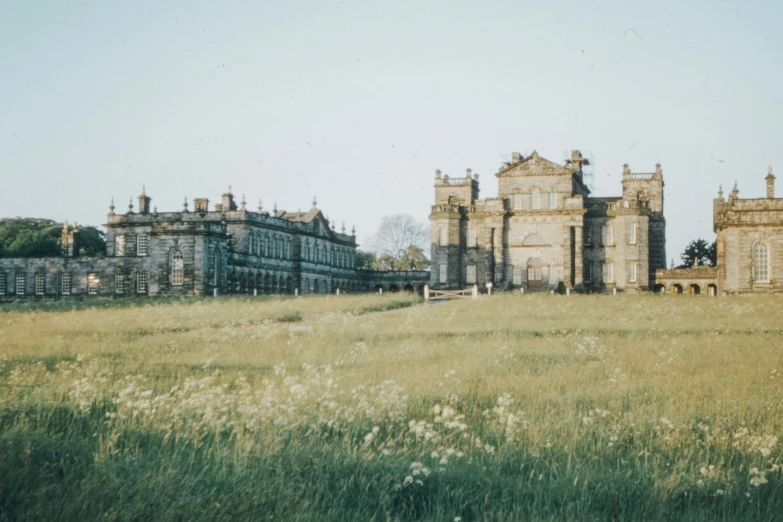 a large castle like building next to a grassy field