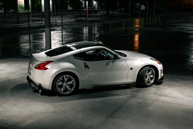 a white sports car sits parked on a dark street