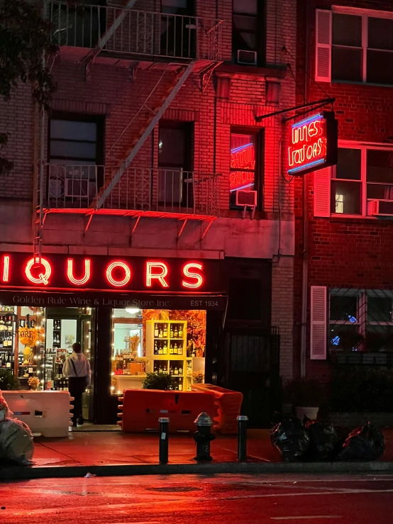 there is a neon sign on the entrance to liquors