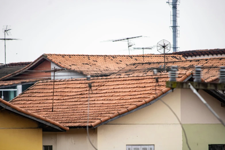 the building with the red roof has a lot of electrical wires and a tower