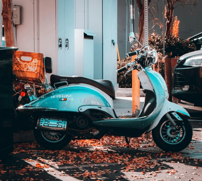 a parked scooter next to a building near a sidewalk