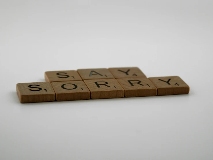 a scrabbled say sorry word spelled with scrabble blocks
