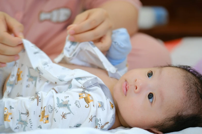 a baby laying on its back with a bandage in it's mouth