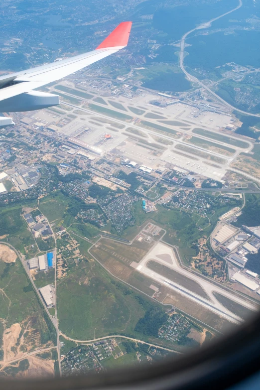 a large wing over some green and brown land