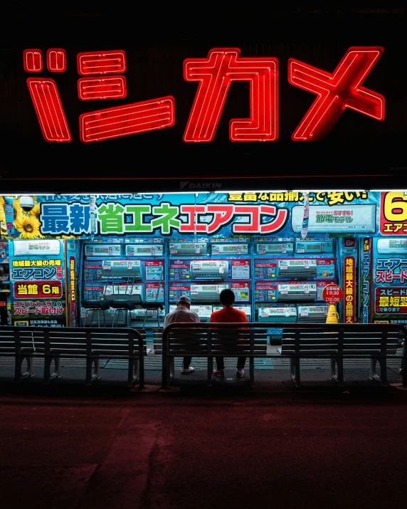 a person sitting on a bench outside a japanese shop