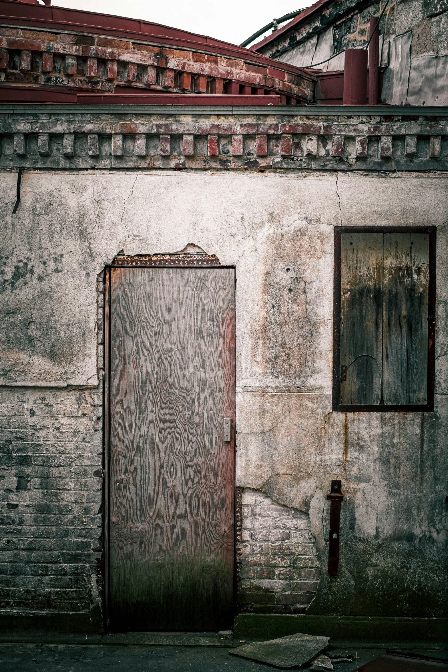 an old building with a boarded up door on the side