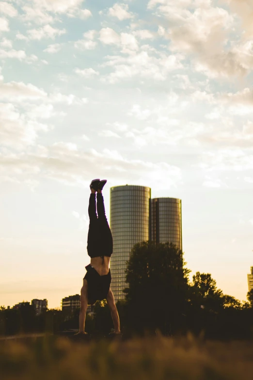 person doing handstand in front of skyscrs