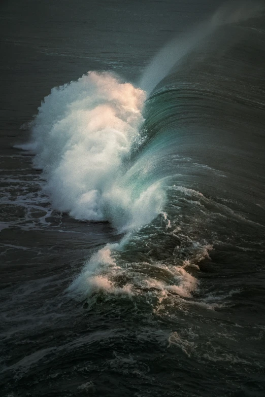 an ocean wave breaking with bright sunlight coming from its top