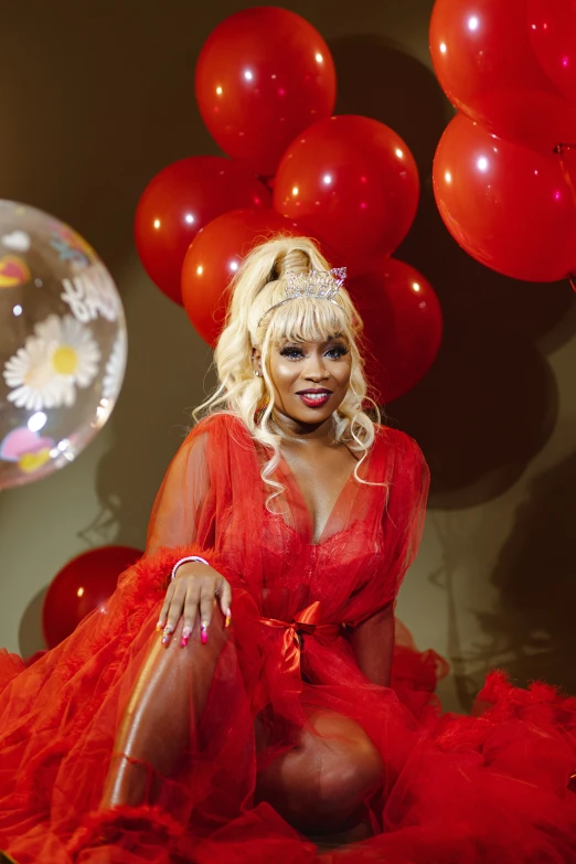 lady in red dress sitting in front of balloon decorations