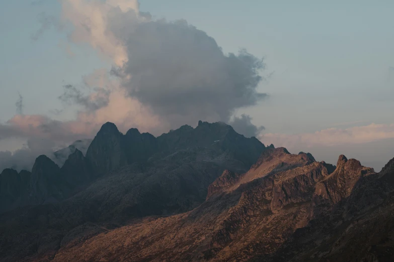 there is a mountain range with dark clouds