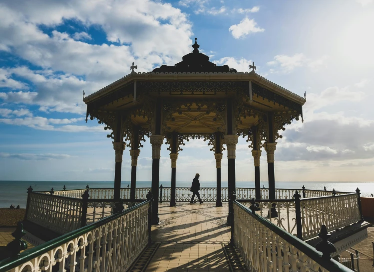 a small pavilion near the beach and people walking