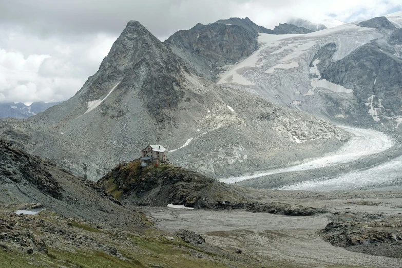 a group of rocky mountain peaks towering above a green field