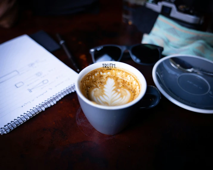 a cup of latte art with a spoon sitting on a table