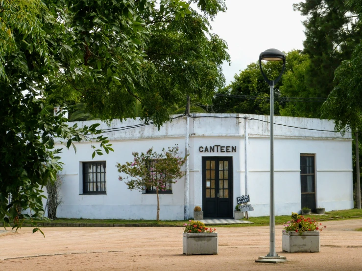 an old - fashioned white building with planters outside