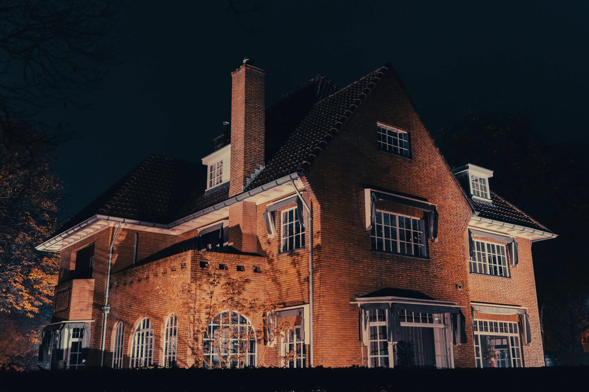 a large brick building with three windows at night