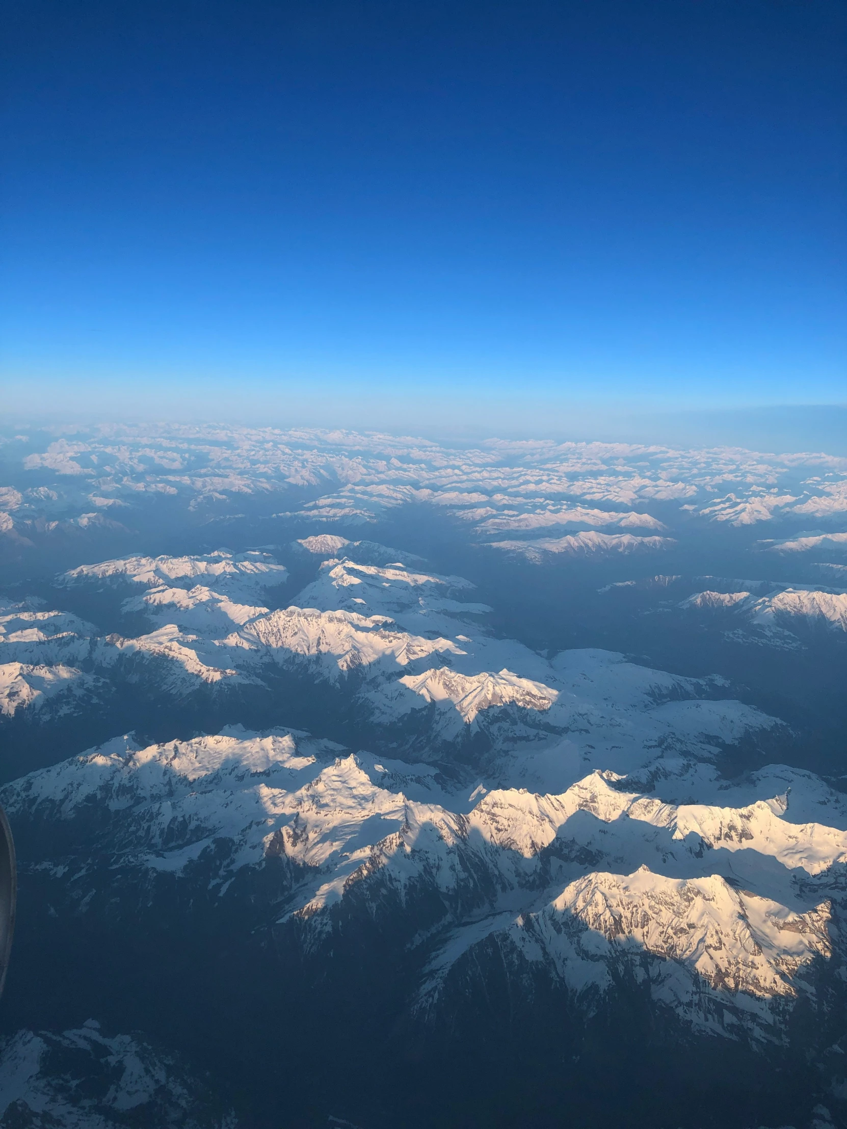 a bird - eye view of snowy mountains and clouds in flight