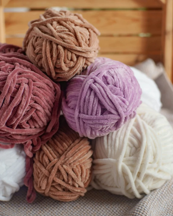 a pile of ball of yarn sitting on top of a bed